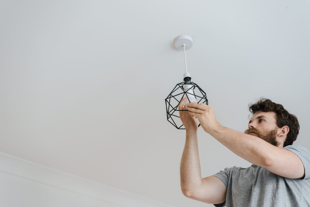 Person fitting a pendant light to a ceiling rose