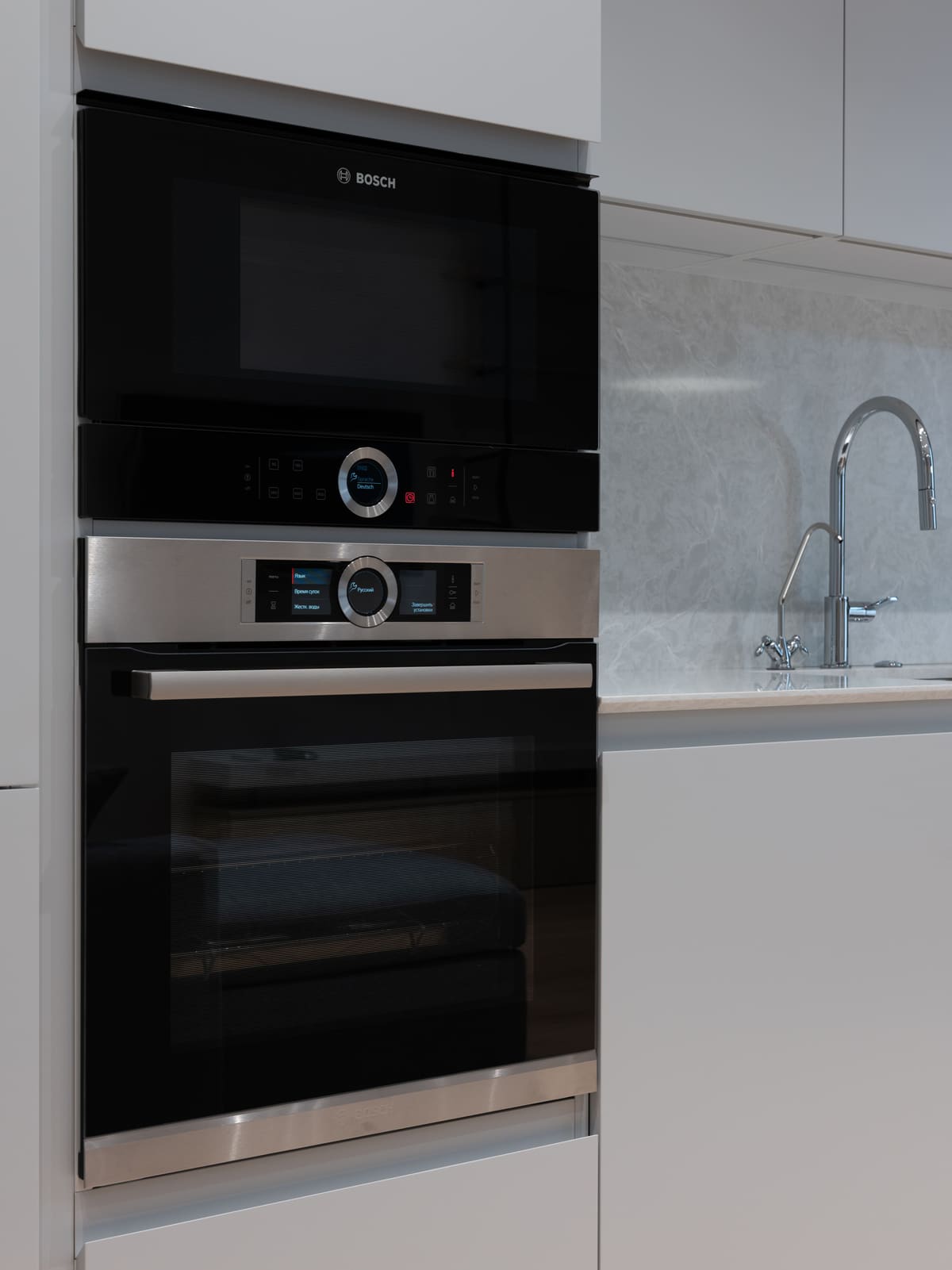 Built-in microwave and oven stack fitted into a kitchen cabinet run
