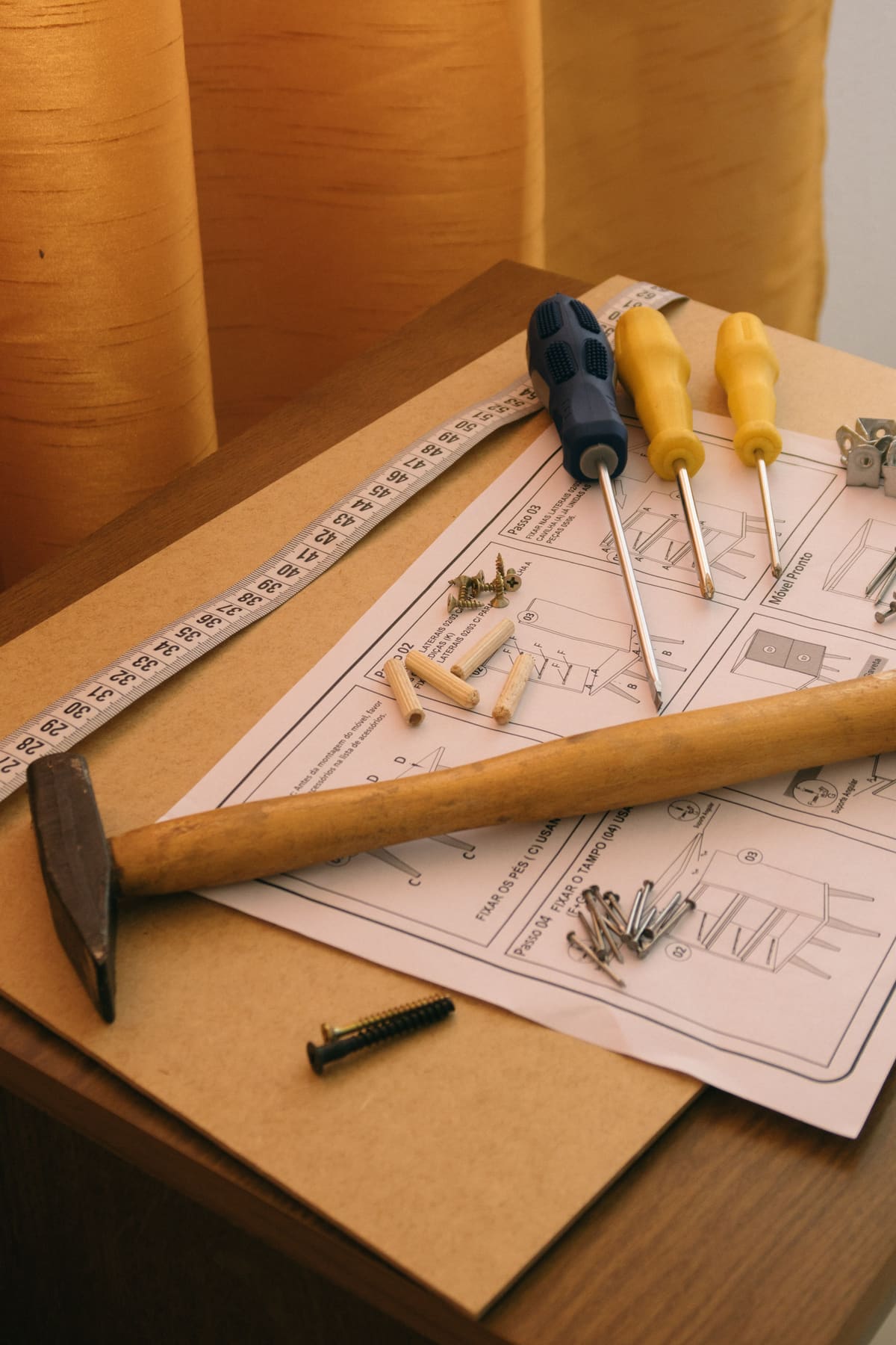 Hammer, screwdrivers and a tape measure laid out on a workbench