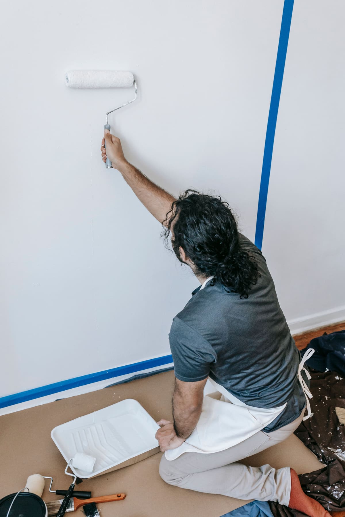 Wall being prepared and cut in with painter's tape along the edge
