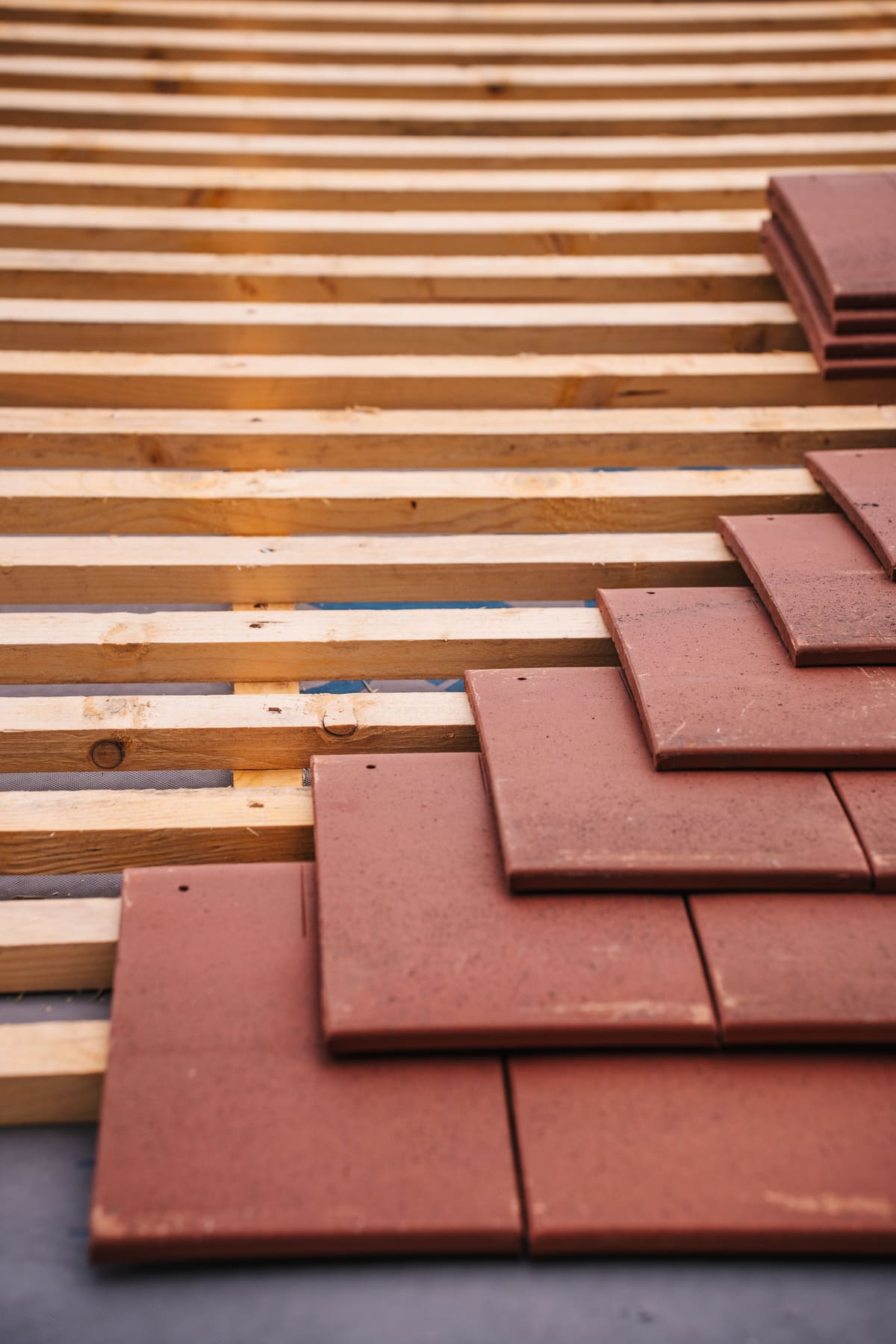 Stacked roofing tiles ready to be laid along a roof edge