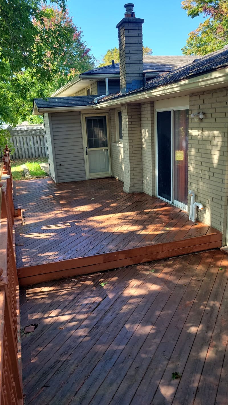 Backyard deck cleaned and freshly stained, with the boards refastened and the steps finished