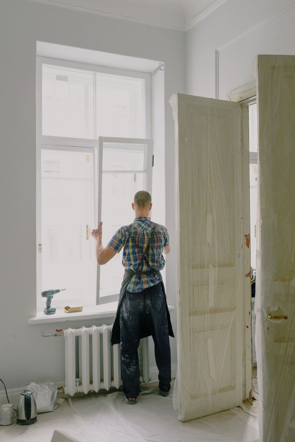 Tradesperson working at a window opening inside a room