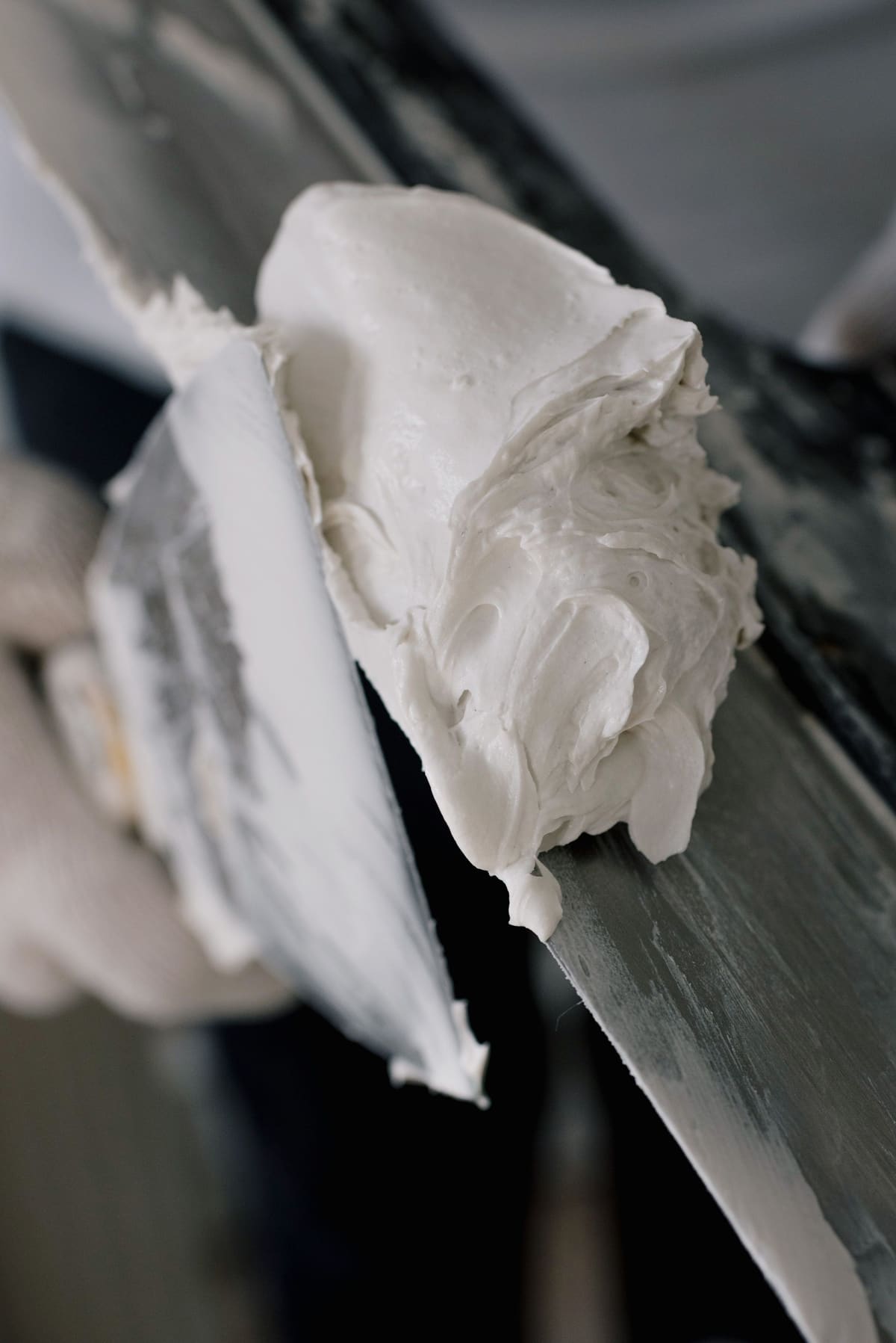 Taping knife loaded with joint compound ready to fill a patch