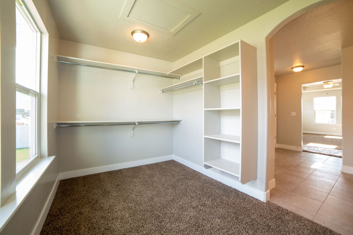 Empty closet fitted out with shelving and a hanging rail