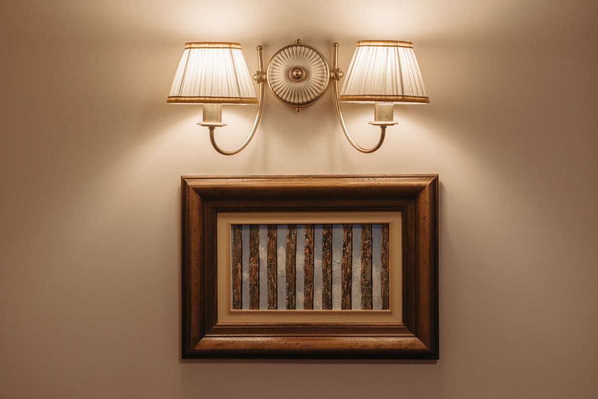 Framed picture and wall sconces hung level as a group