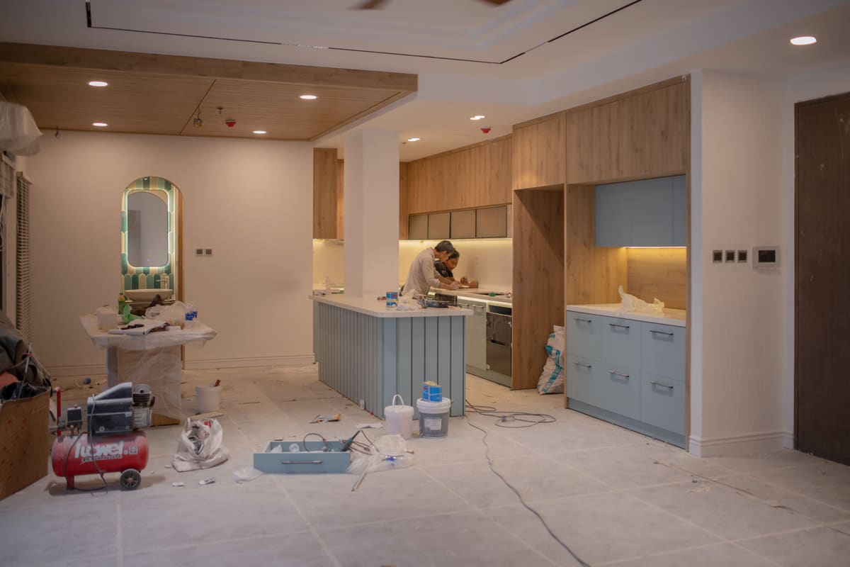 Kitchen mid-renovation with tools and materials laid out across the floor